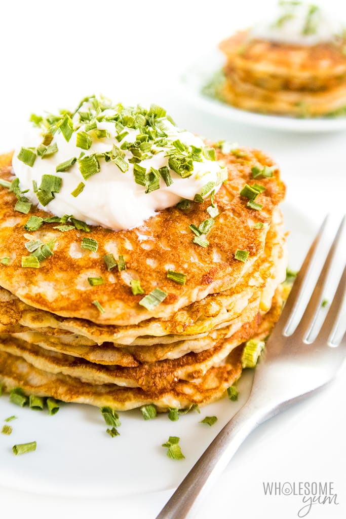 zucchini pancakes recipe - stack of zucchini pancakes with sour cream and chives
