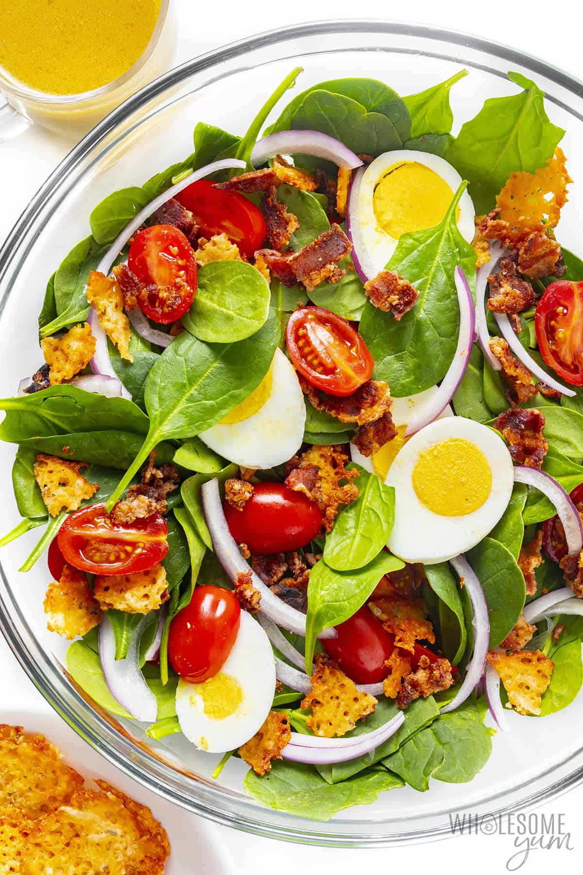 Spinach bacon salad in a large bowl.