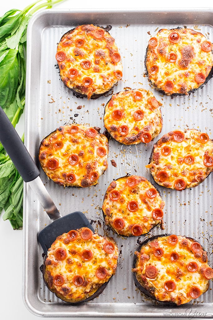 Eggplant Pizzas on a pan with one being served with a spatula
