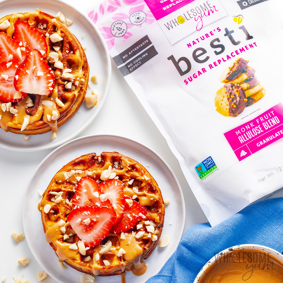 Peanut butter waffles drizzled with melted peanut butter, and topped with strawberry slices.