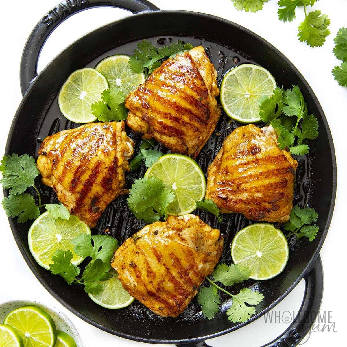 Cilantro lime chicken with lime wedges and fresh cilantro.