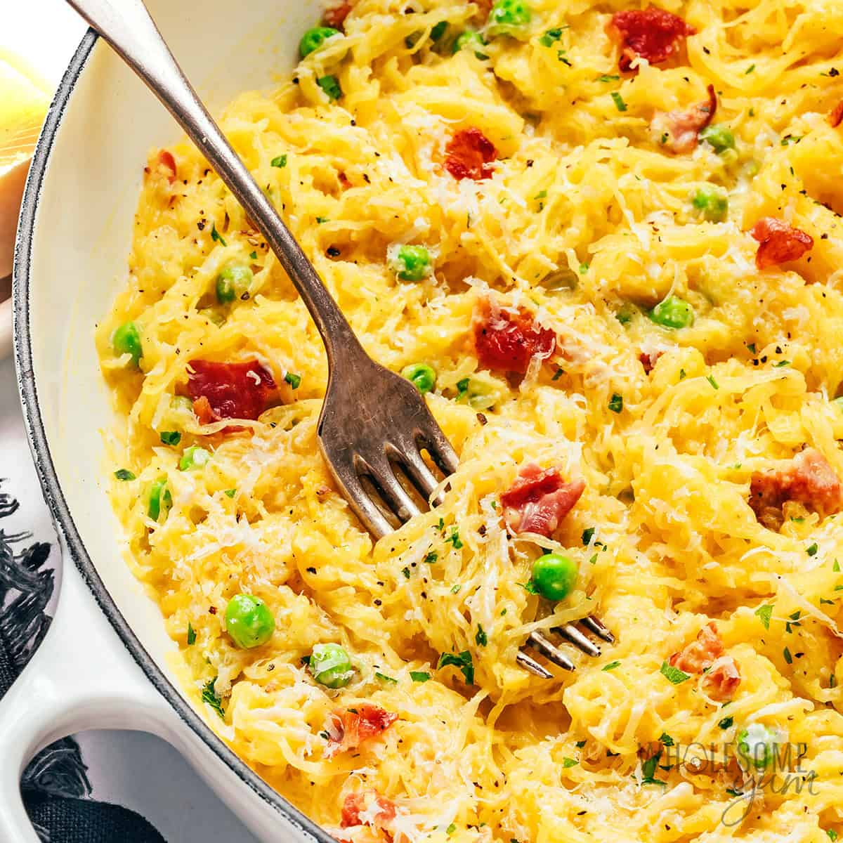 Spaghetti squash carbonara twirled around a fork.