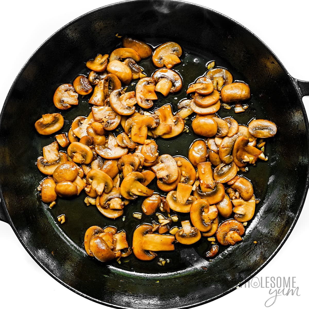 Mushrooms and garlic in cast iron skillet.