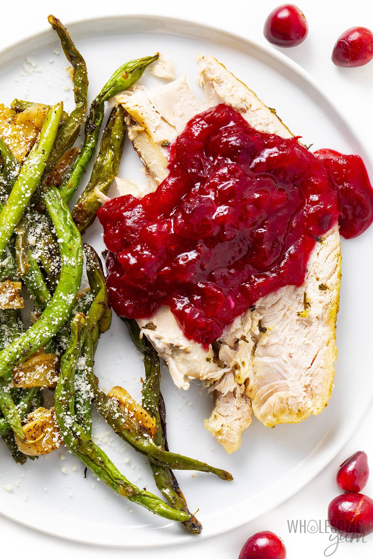 Low carb cranberry sauce on top of turkey next to green beans. 