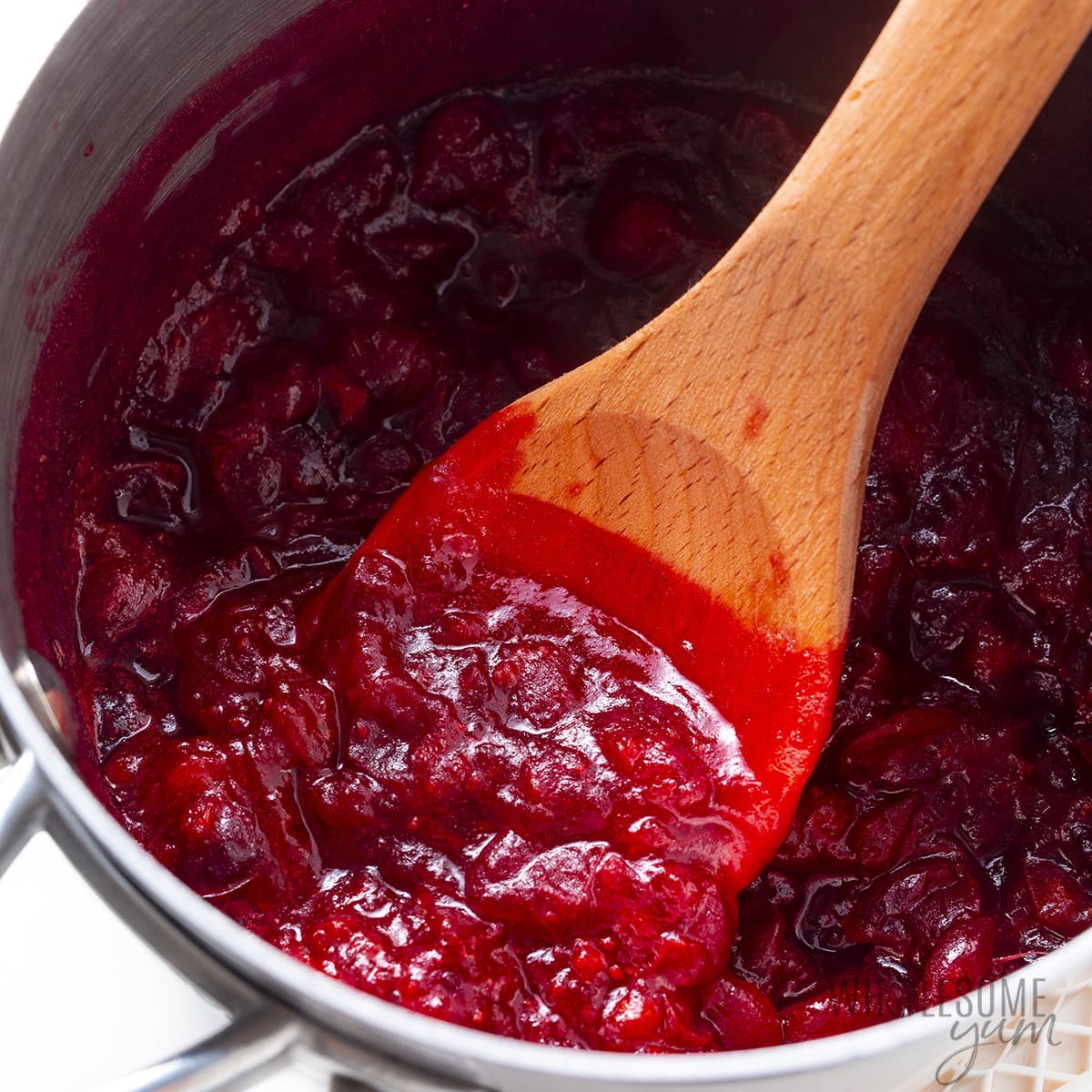 Keto cranberry sauce with wooden spoon.