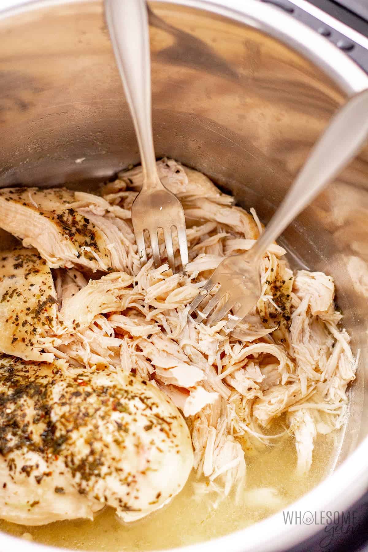 Shredding chicken in the Instant Pot with two forks.