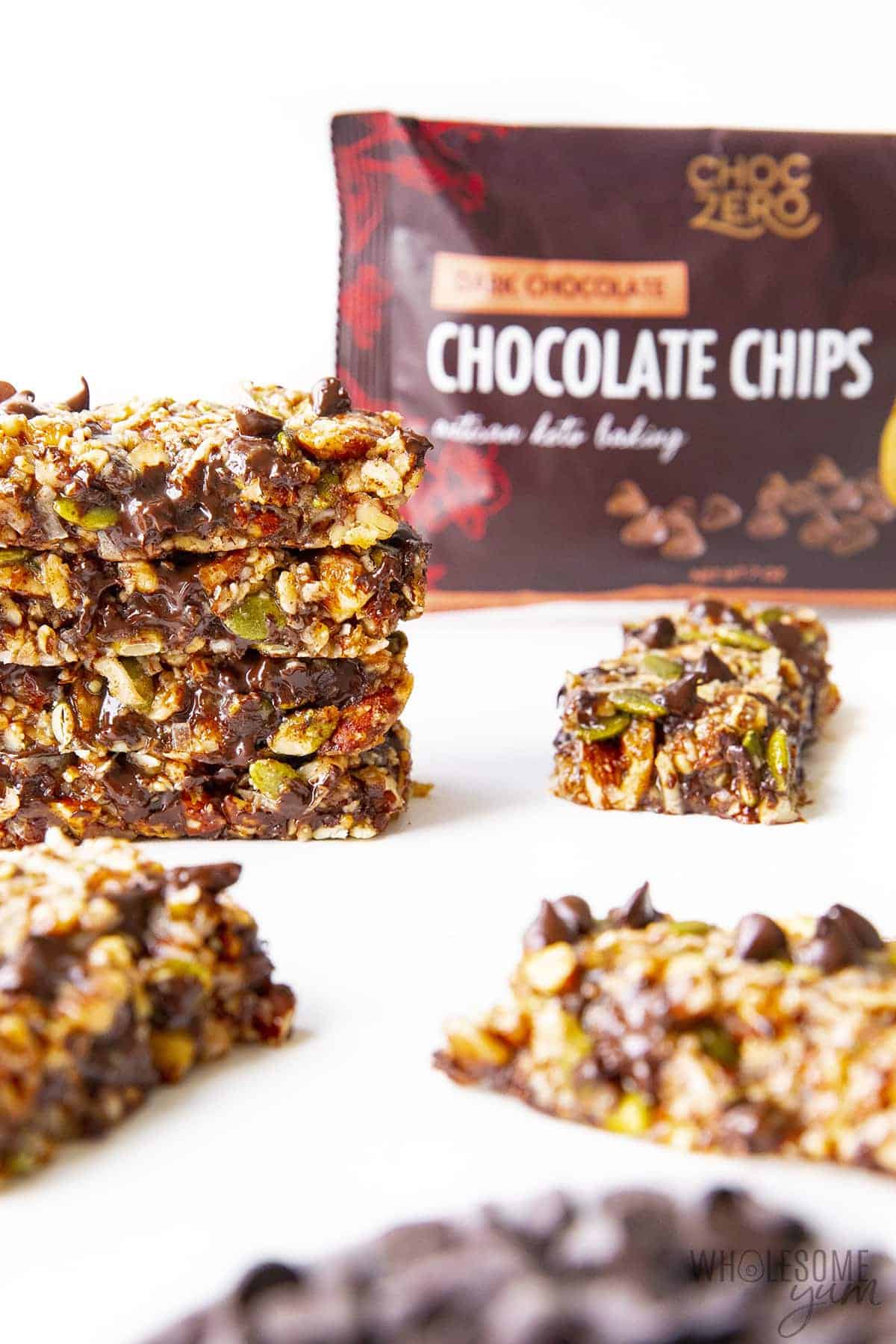 Stacked low carb granola bars with a bag of ChocZero chocolate chips in the background