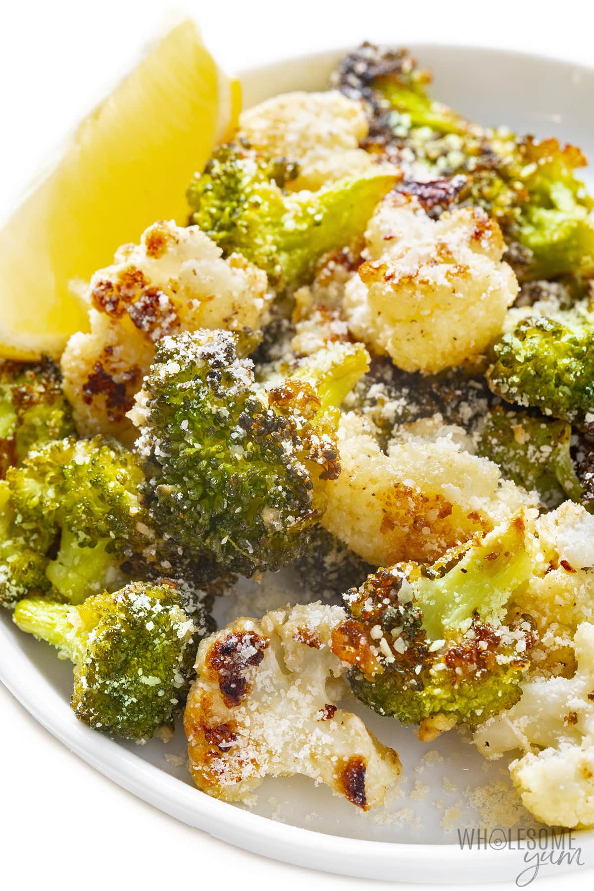 Roasted parmesan broccoli and cauliflower on a plate.