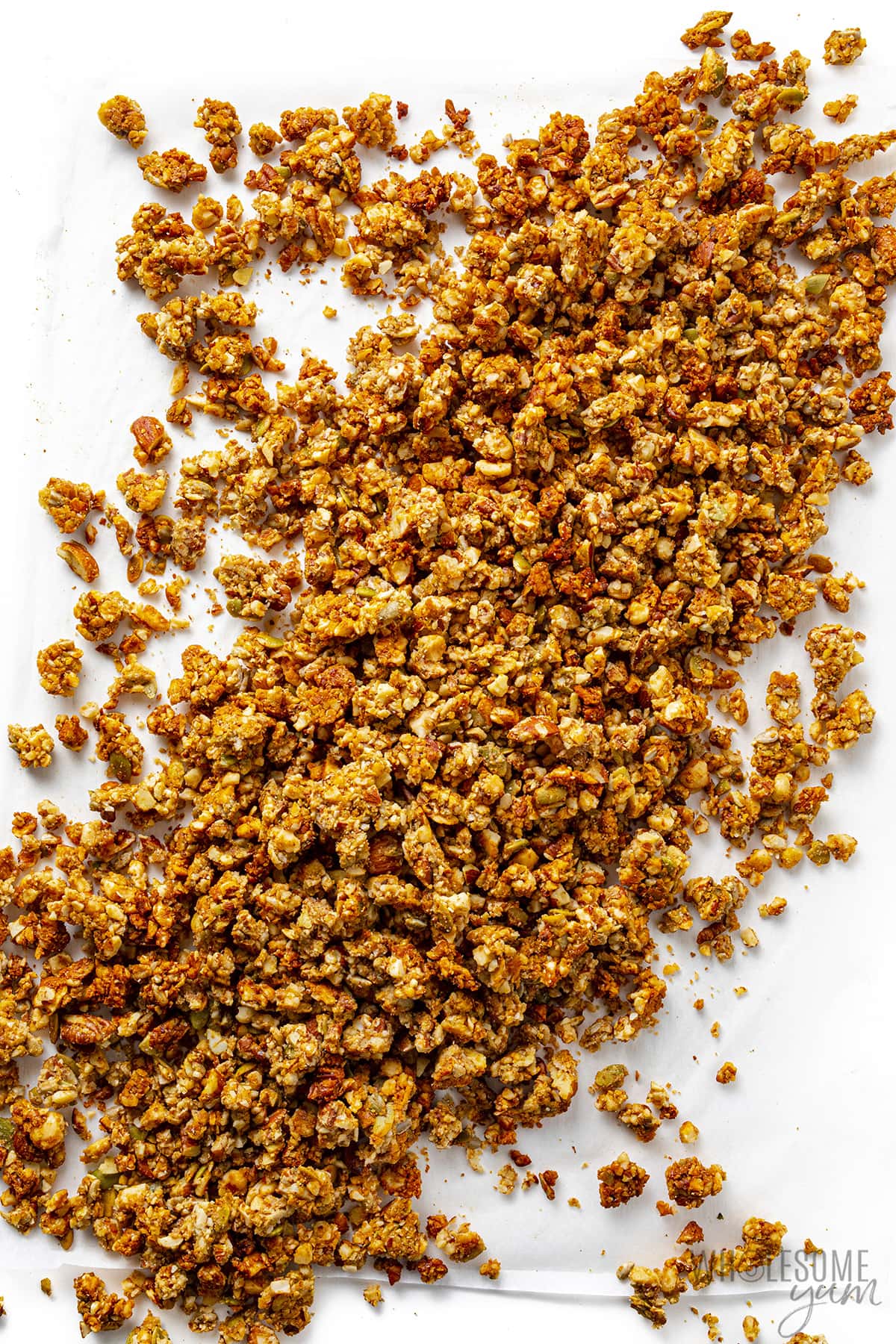 Low carb keto granola spread out on parchment paper.