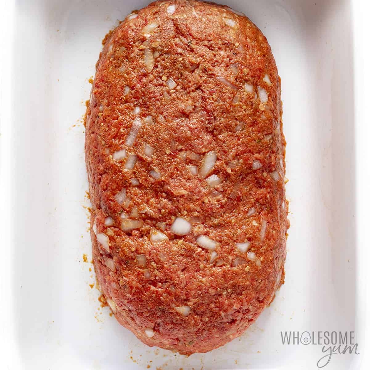 Shaped paleo meatloaf in a baking dish.