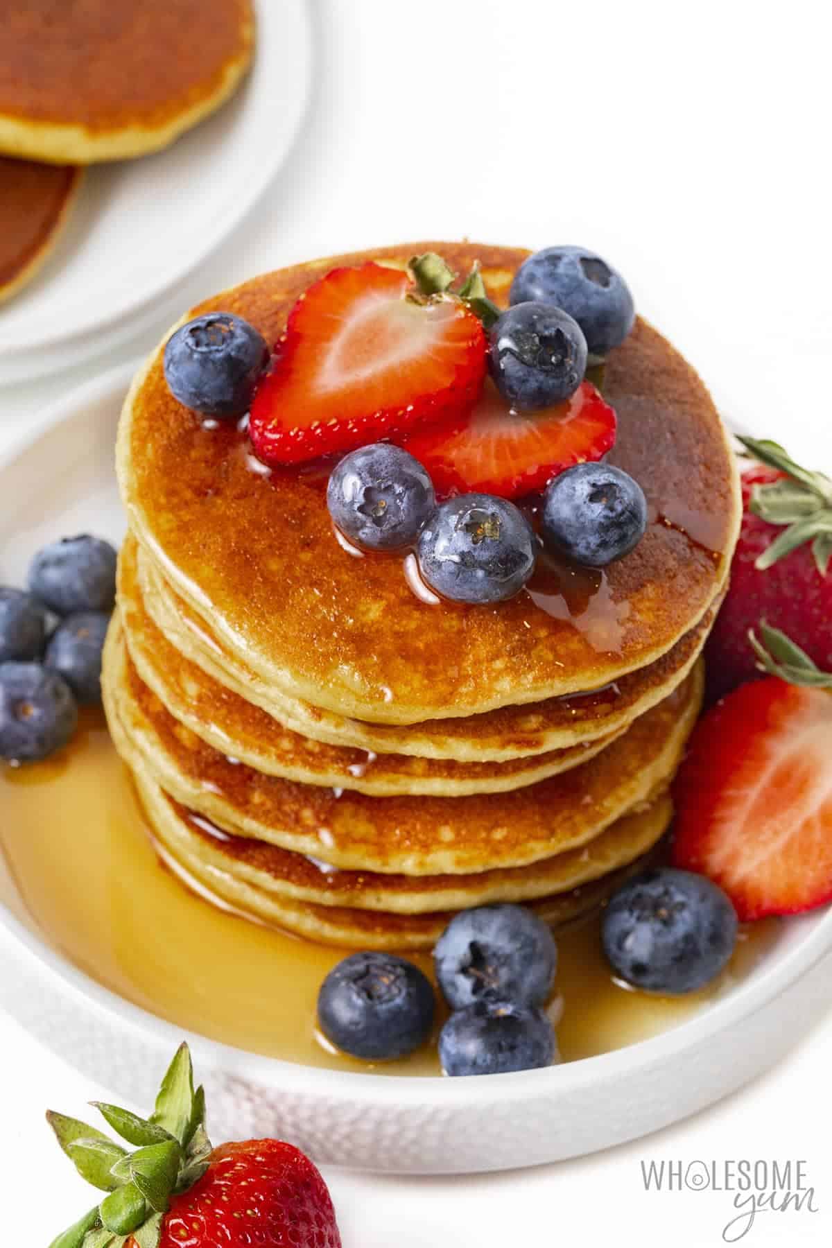 Low carb pancakes with berries and syrup.