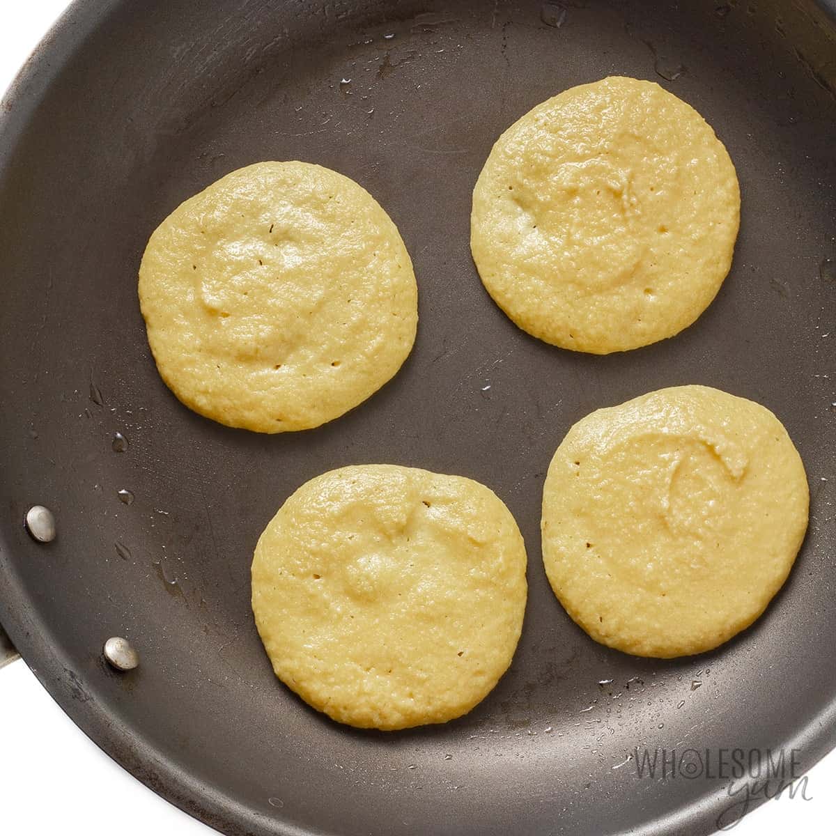 Frying keto pancakes - shown with bubbles on the edges.