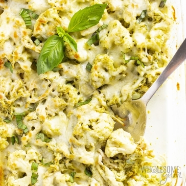 Pesto chicken cauliflower casserole recipe with a spoon and basil on top