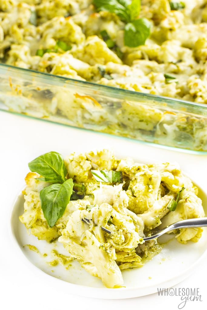 Side view of keto chicken cauliflower casserole with a fork and basil leaves