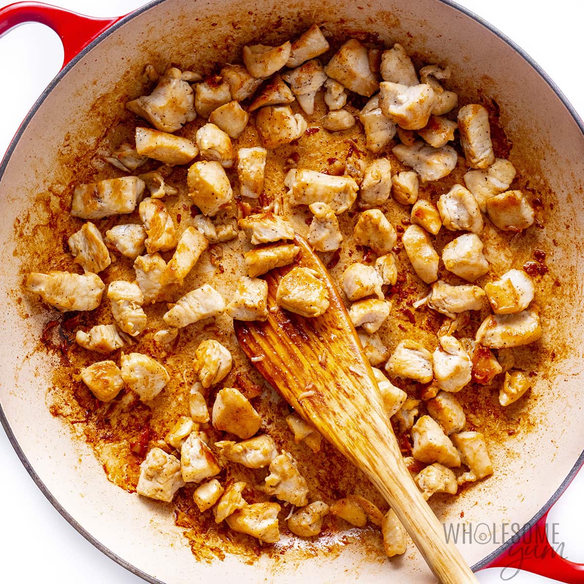 Golden brown chicken pieces in a pan.
