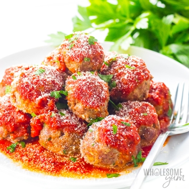 Pile of low carb keto meatballs with marinara sauce and cheese, on a plate