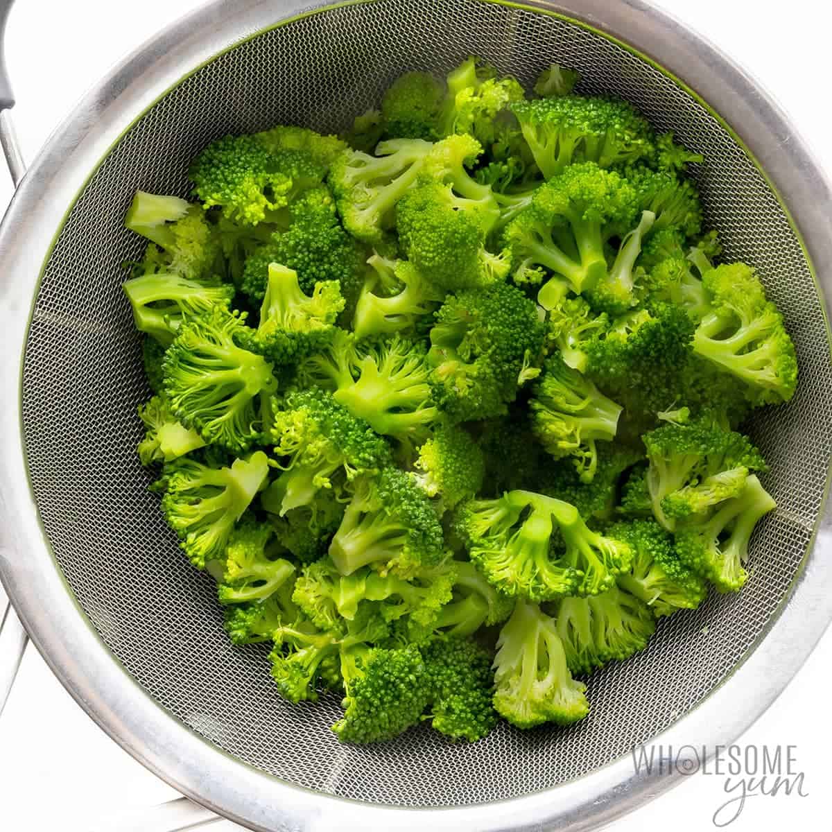 Cooked broccoli in a colander