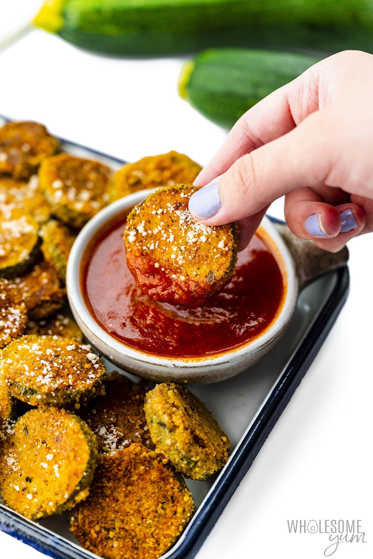 Fried zucchini dipped into sauce.