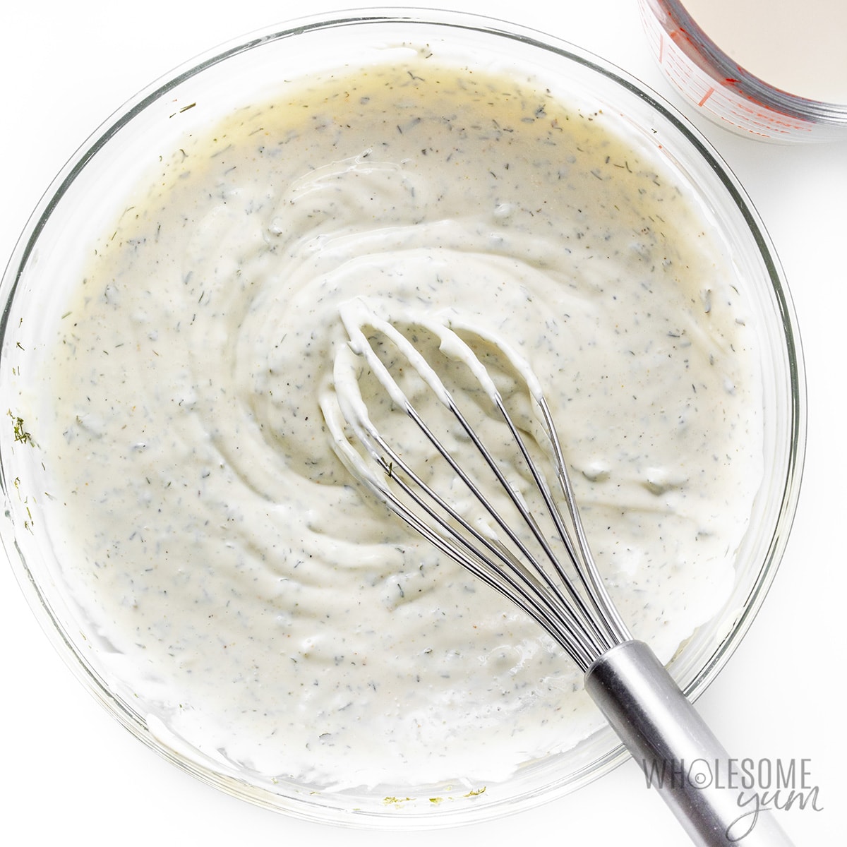 Homemade ranch dressing whisked in a bowl.