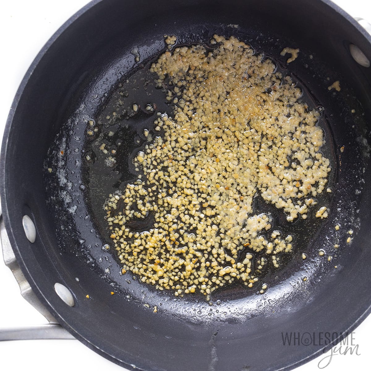 Sauteed minced garlic in a saucepan.