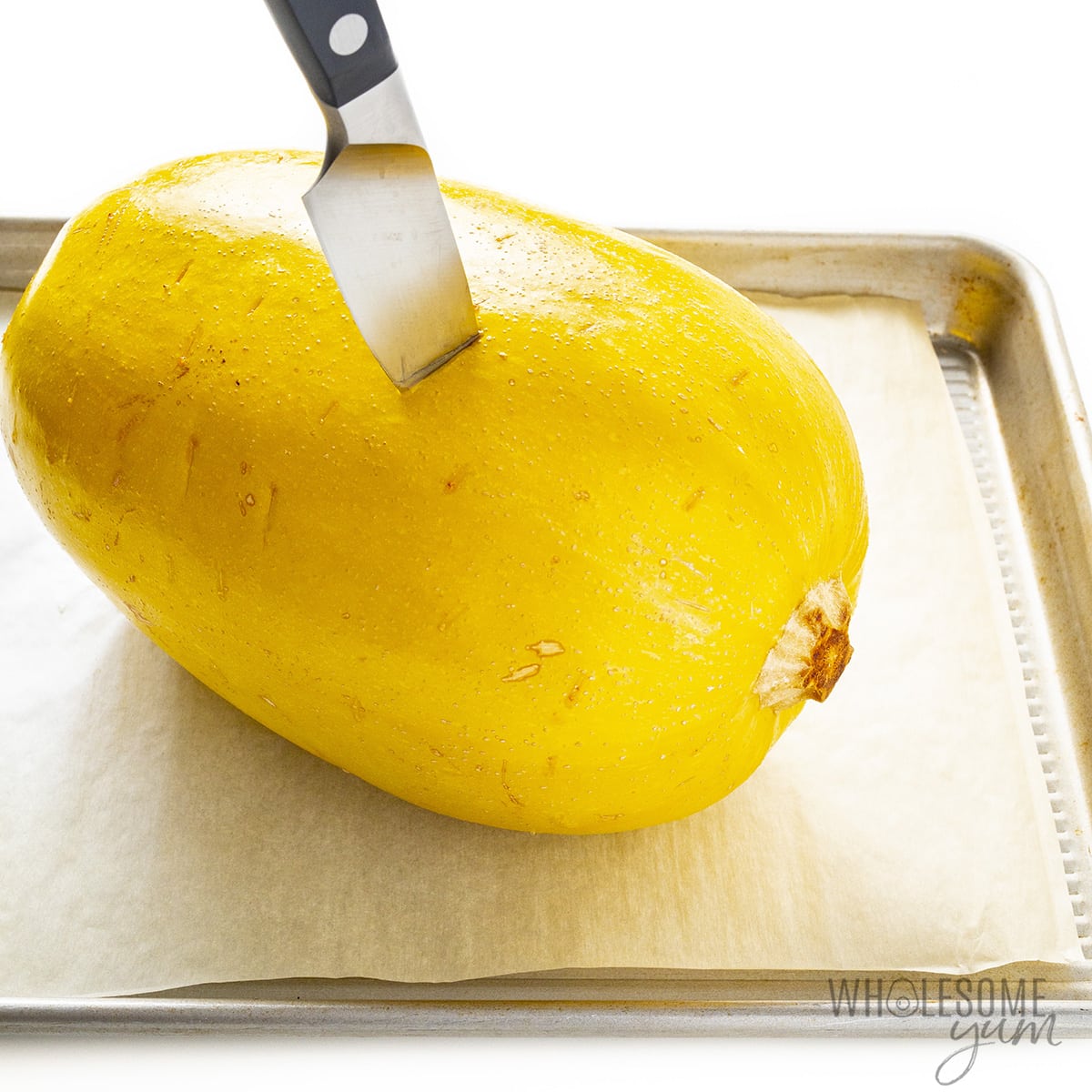 Cooked squash with knife inserted.