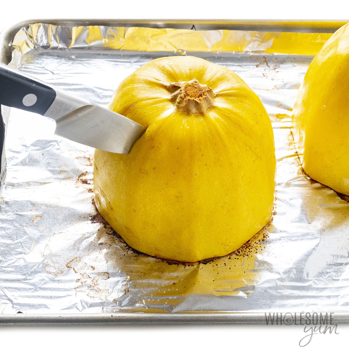 Halved squash with knife inserted.