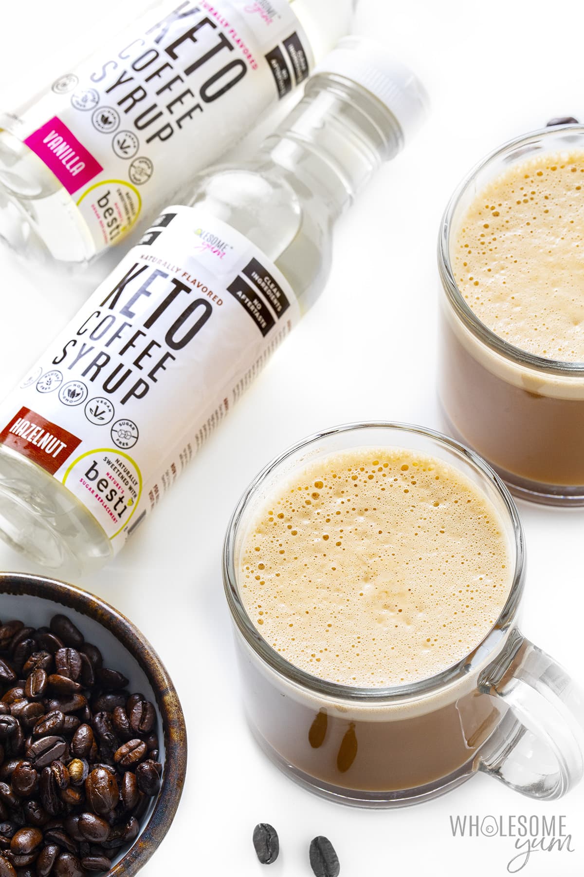 Bulletproof coffee next to bottles of Wholesome Yum keto coffee syrups.