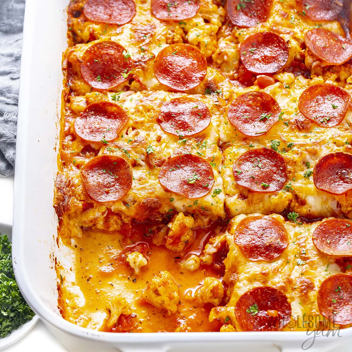 Finished pepperoni pizza casserole with a serving removed.