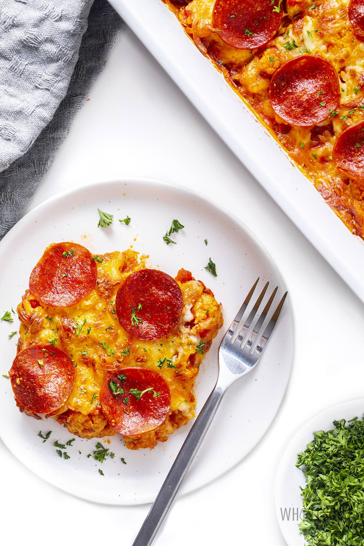 A serving of keto pizza casserole on a plate with a fork.