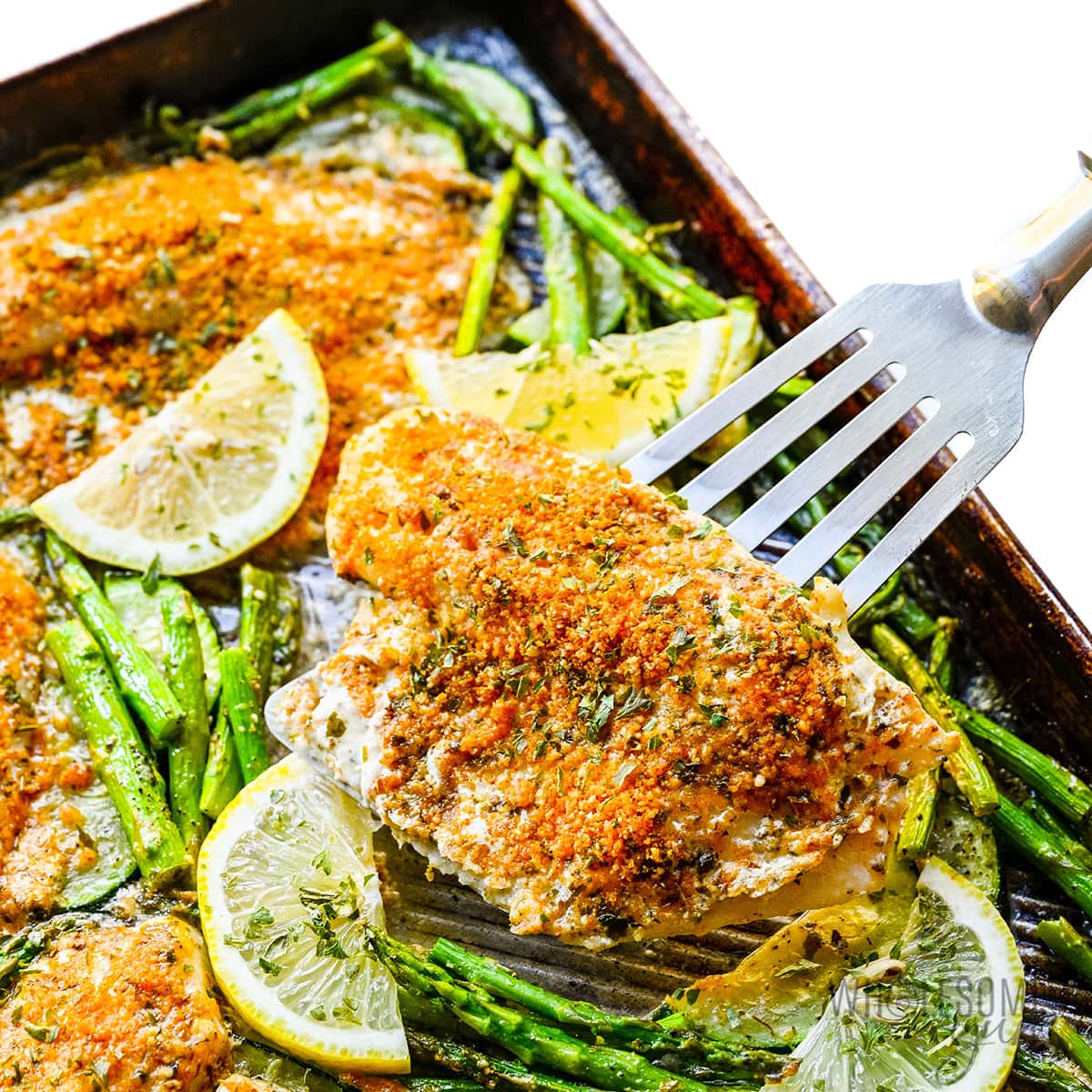 Parmesan crusted tilapia with spatula.