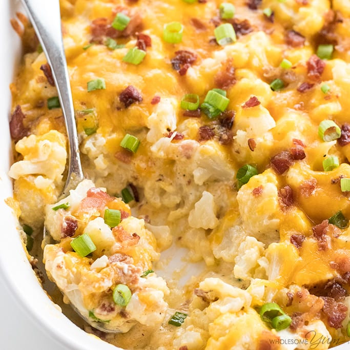 loaded cauliflower casserole being served with a spoon Detail: easy-cheesy-loaded-cauliflower-casserole-recipe-3