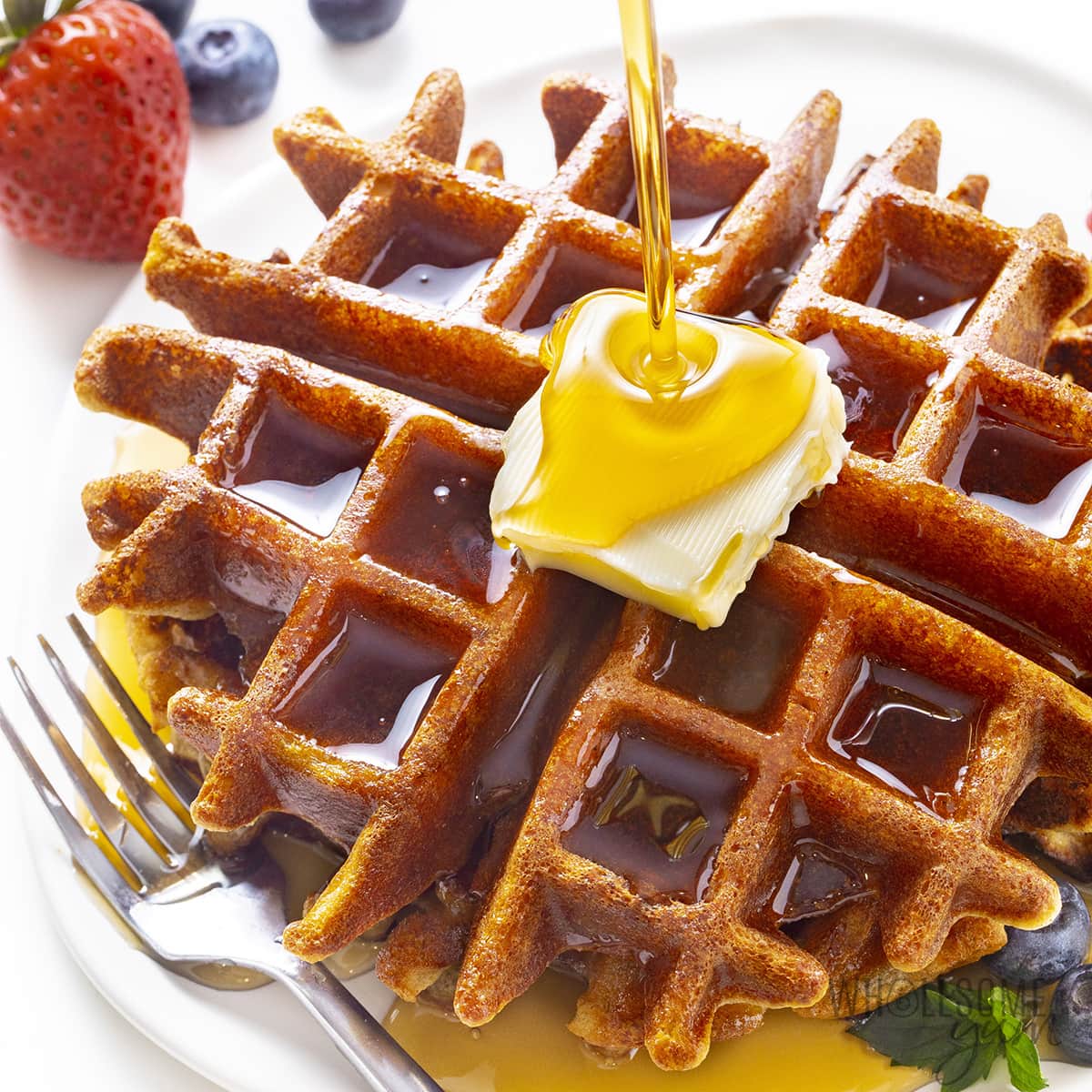 Keto almond flour waffles on a plate with syrup.