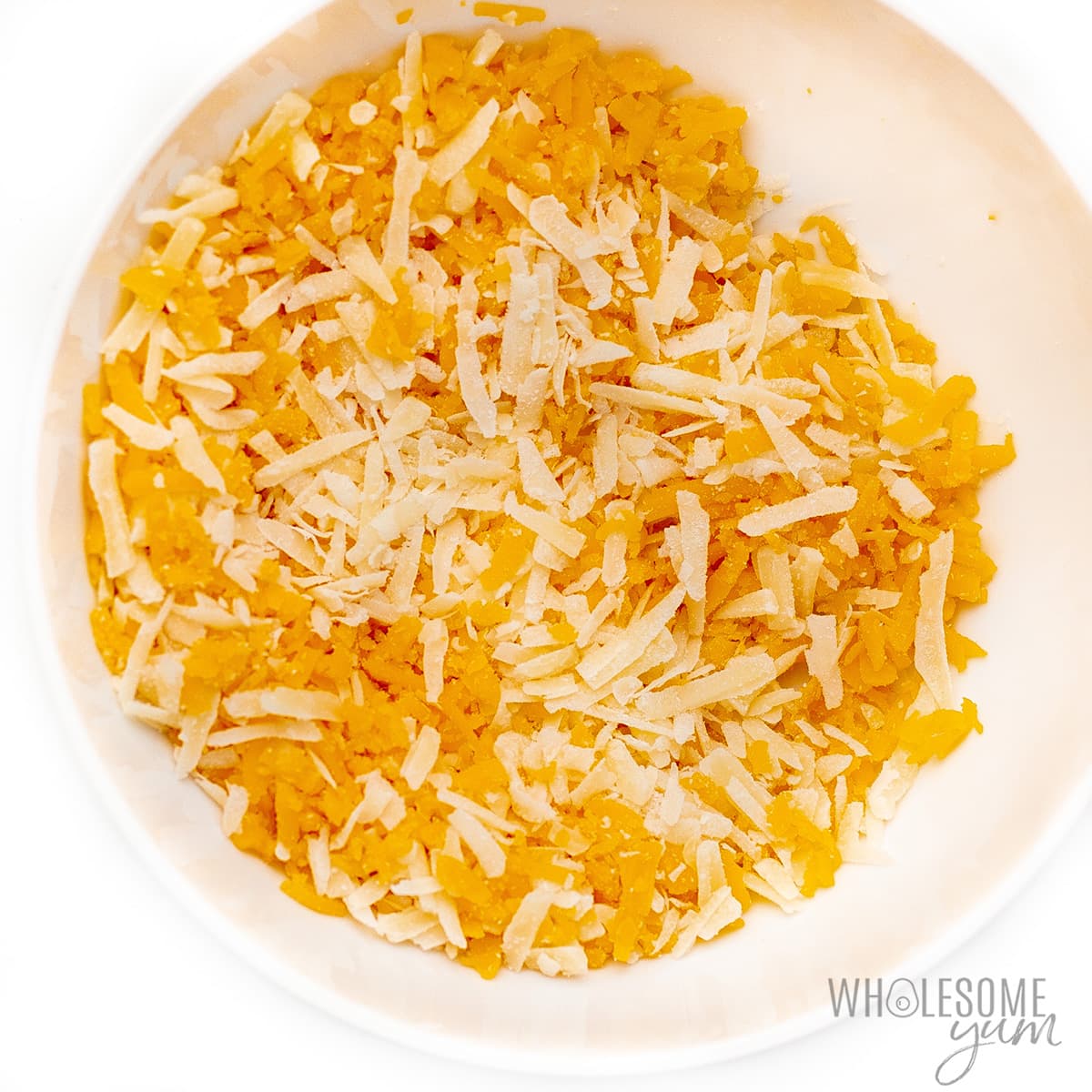 Shredded cheese mixed in a bowl.