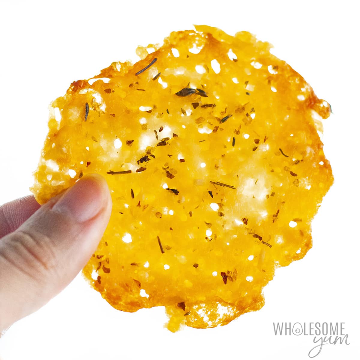 Cheese crisps shown close up in hand.