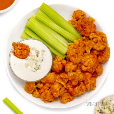Buffalo cauliflower recipe on a plate, with blue cheese and celery.