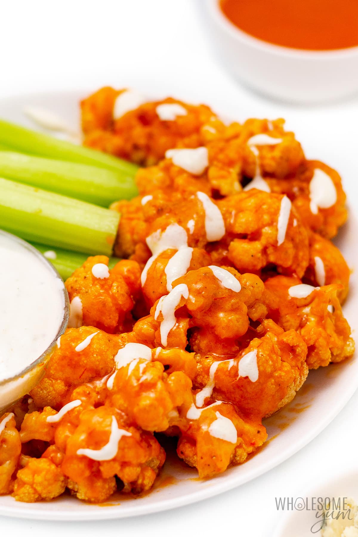Buffalo cauliflower wings with blue cheese drizzled on top.