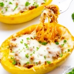 Stuffed spaghetti squash lasagna with some noodles removed with a fork.