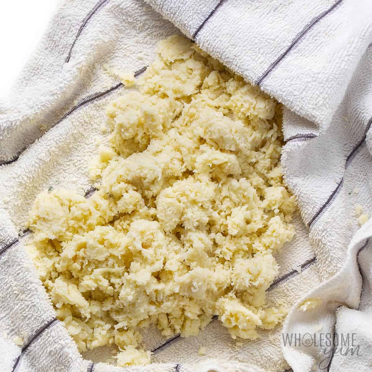 Riced cauliflower with moisture squeezed out in kitchen towel