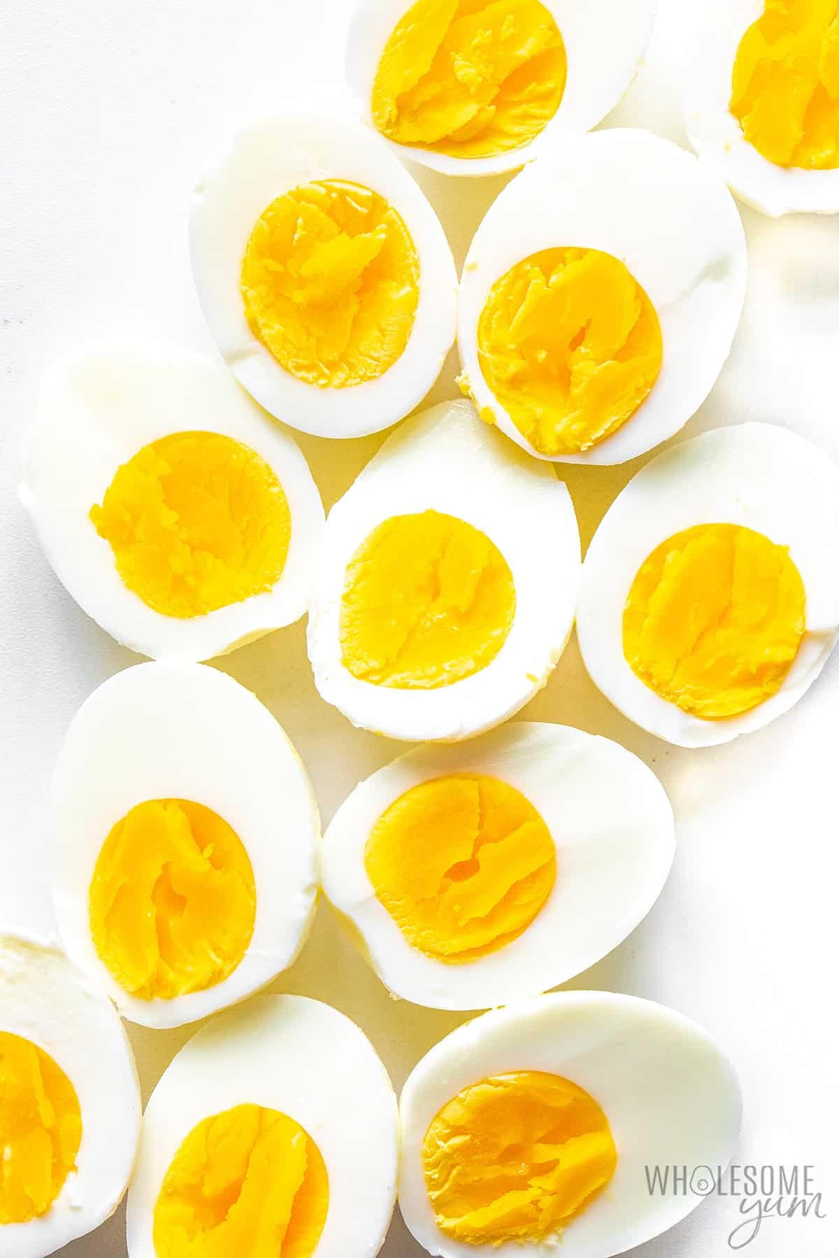 Perfect hard boiled eggs scattered on a white surface