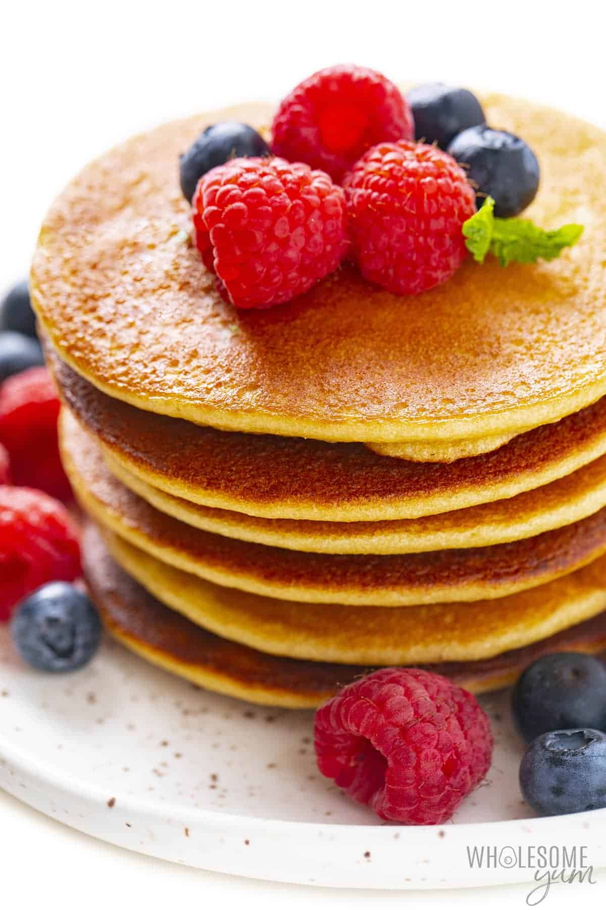 Stack of keto pancakes with almond flour, garnished with berries.