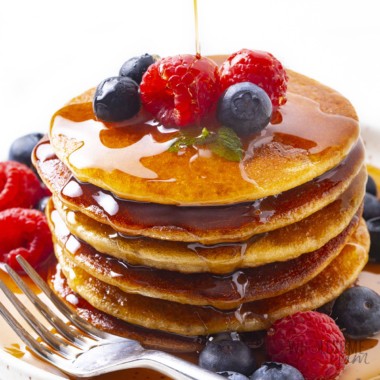 Stack of almond pancakes drizzled with syrup.