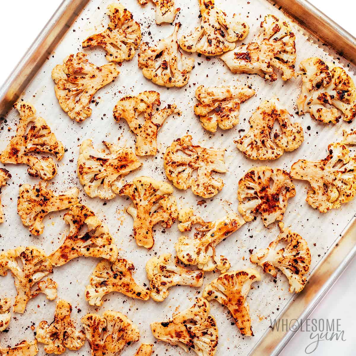 Roasted cauliflower chips on the baking sheet.