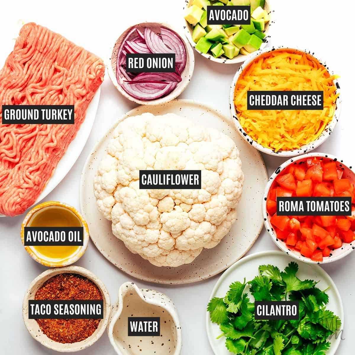 Labeled recipe ingredients: Cauliflower, avocado oil, taco seasoning, ground turkey, water, cheddar cheese, red onion, Roma tomatoes, avocado, and fresh cilantro.