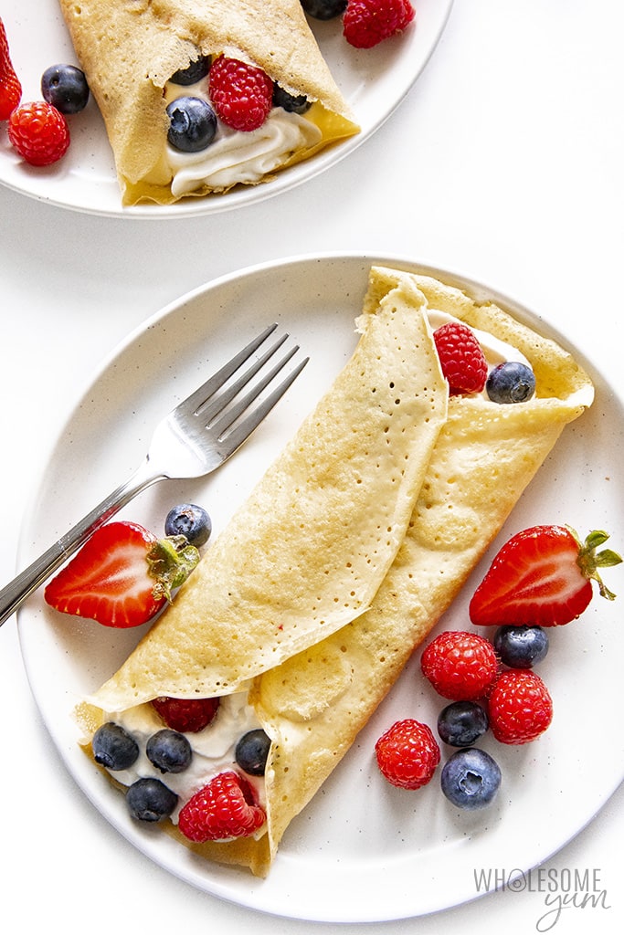 Keto crepes rolled up with whipped cream and berries