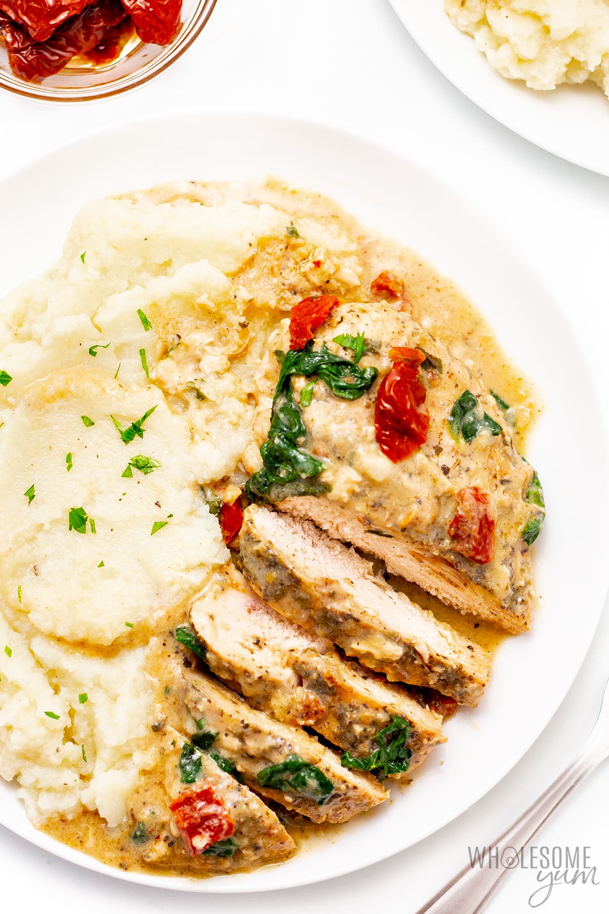 Sliced creamy Tuscan chicken on a plate.