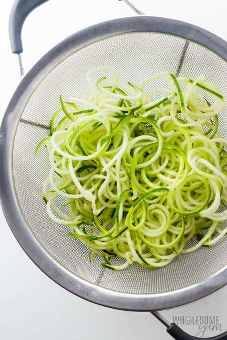 Zucchini noodles draining in a colander