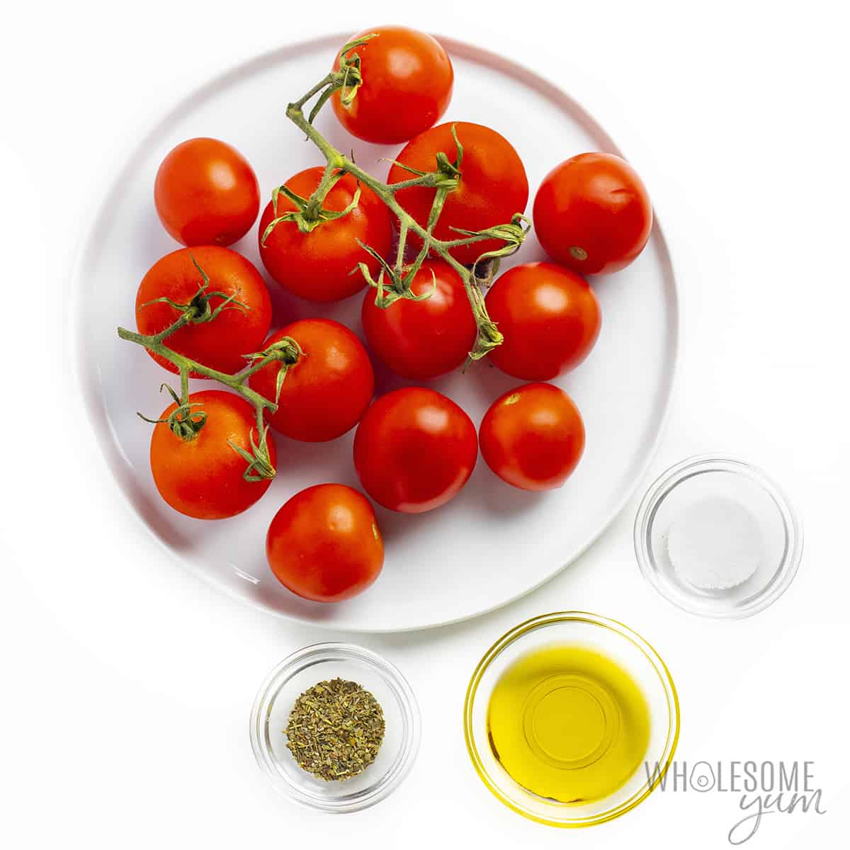 Tomatoes, oil, salt, and seasoning in bowls.