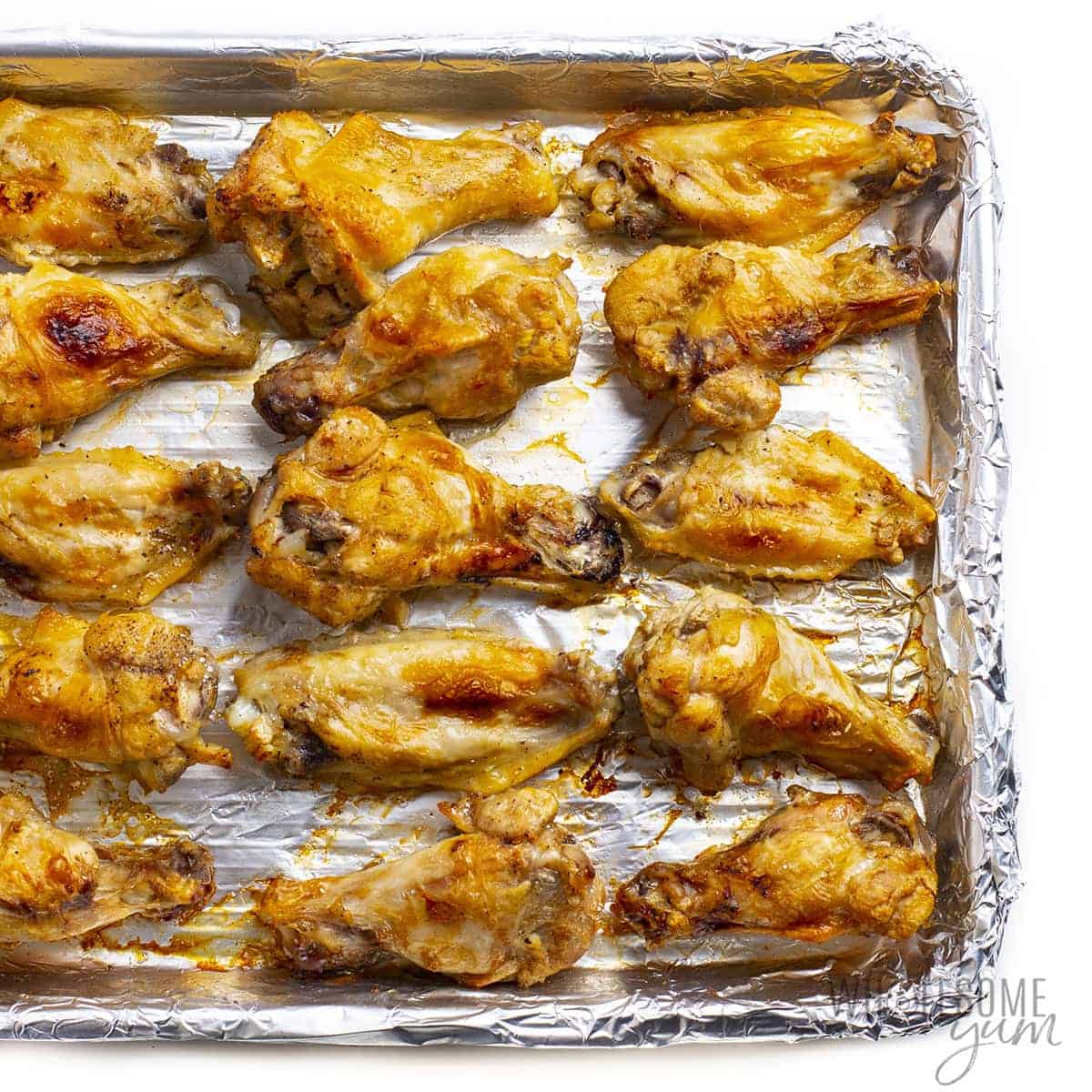 Cooked chicken wings on baking sheet