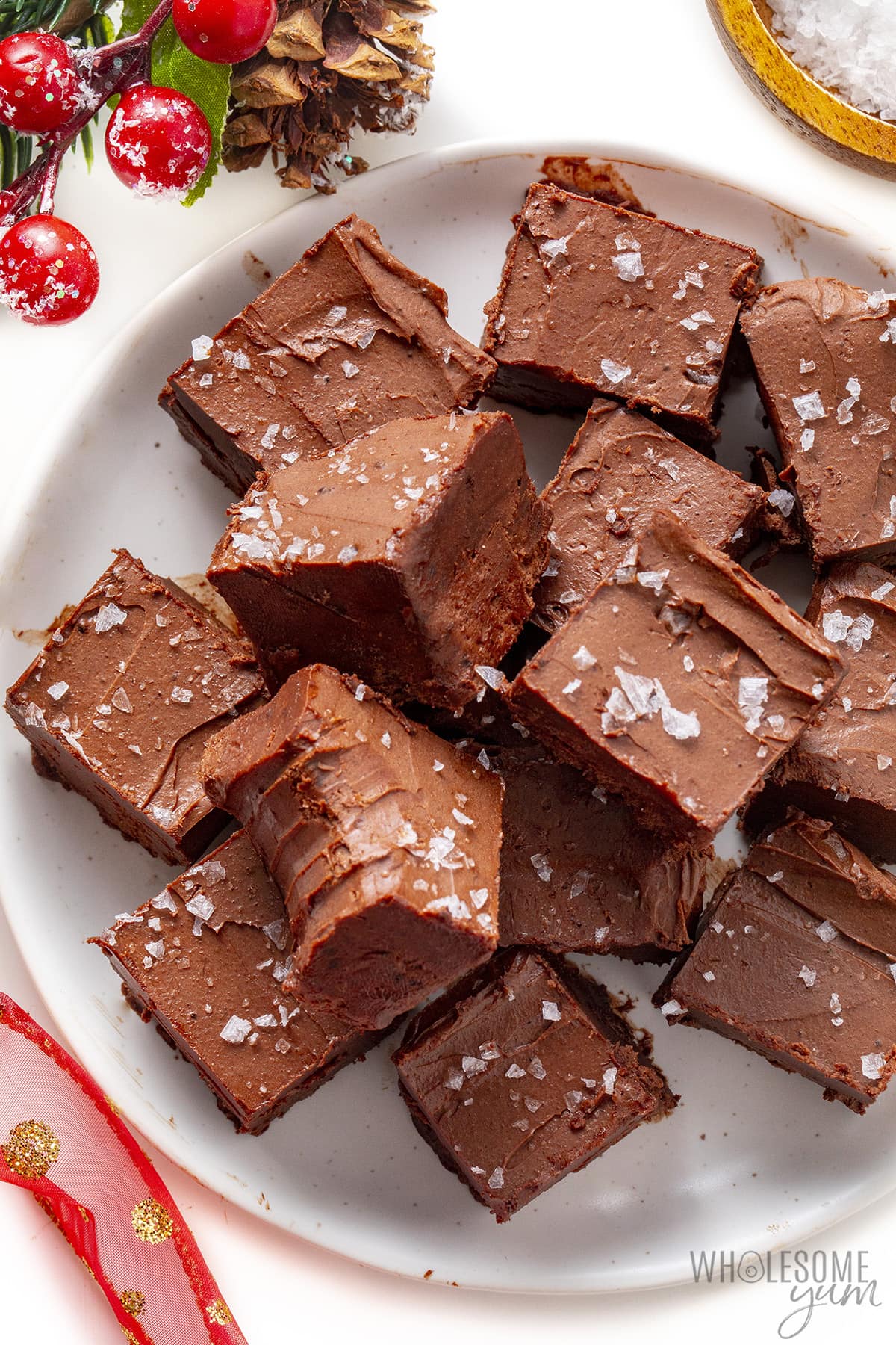 Cubes of sugar-free fudge are piled on the plate, one of which has been bitten off.