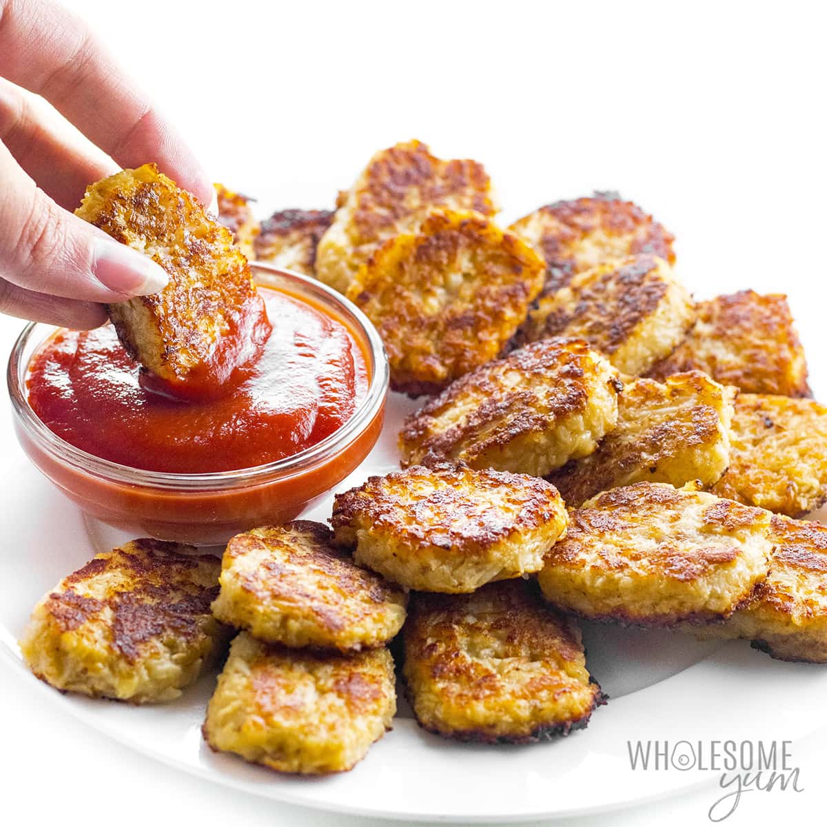 Cauliflower tots dipped in ketchup.